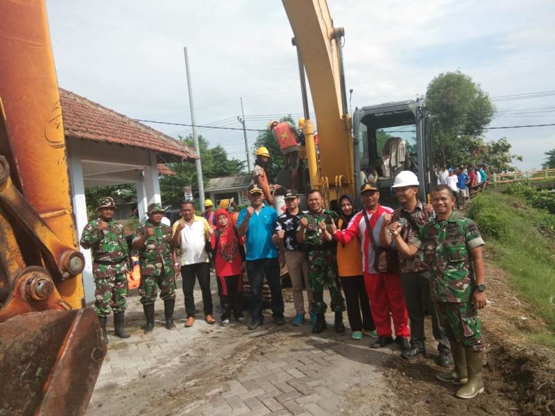 Danramil Sooko Kapten Inf Hari Subiyanto bersama Kepala TKPSDA Surabaya, Camat Sooko, Camat Kesamben dan Para Kades serta Anggota Koramil saat karya bakti pembersihan sungai pekan lalu pose di depan ekskavator
