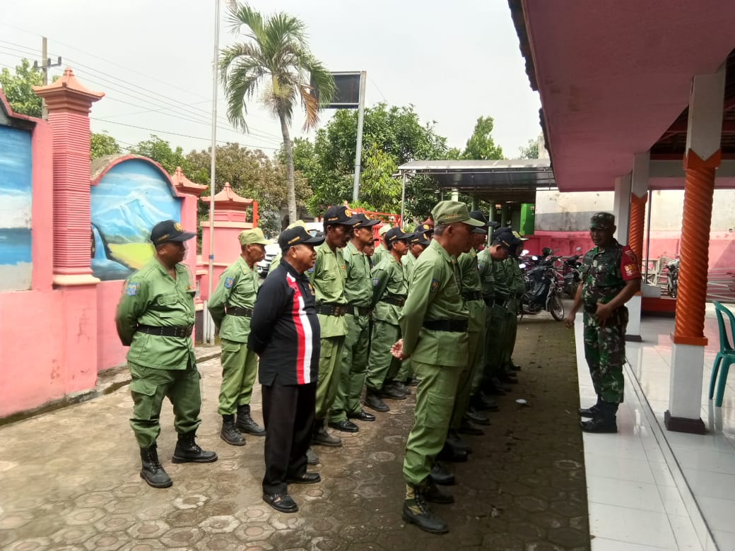 Babinsa Koramil Jatirejo Serka Sholikin saat melatih PBB anggota Linmas di Halaman Pendopo Balai Desa Padang Asri