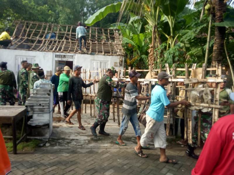 Tampak gabungan Personel TNI, Perangkat Desa Panggih dan Warga Panggih, gotong royong memperbaiki atap rumah Mbah Saman